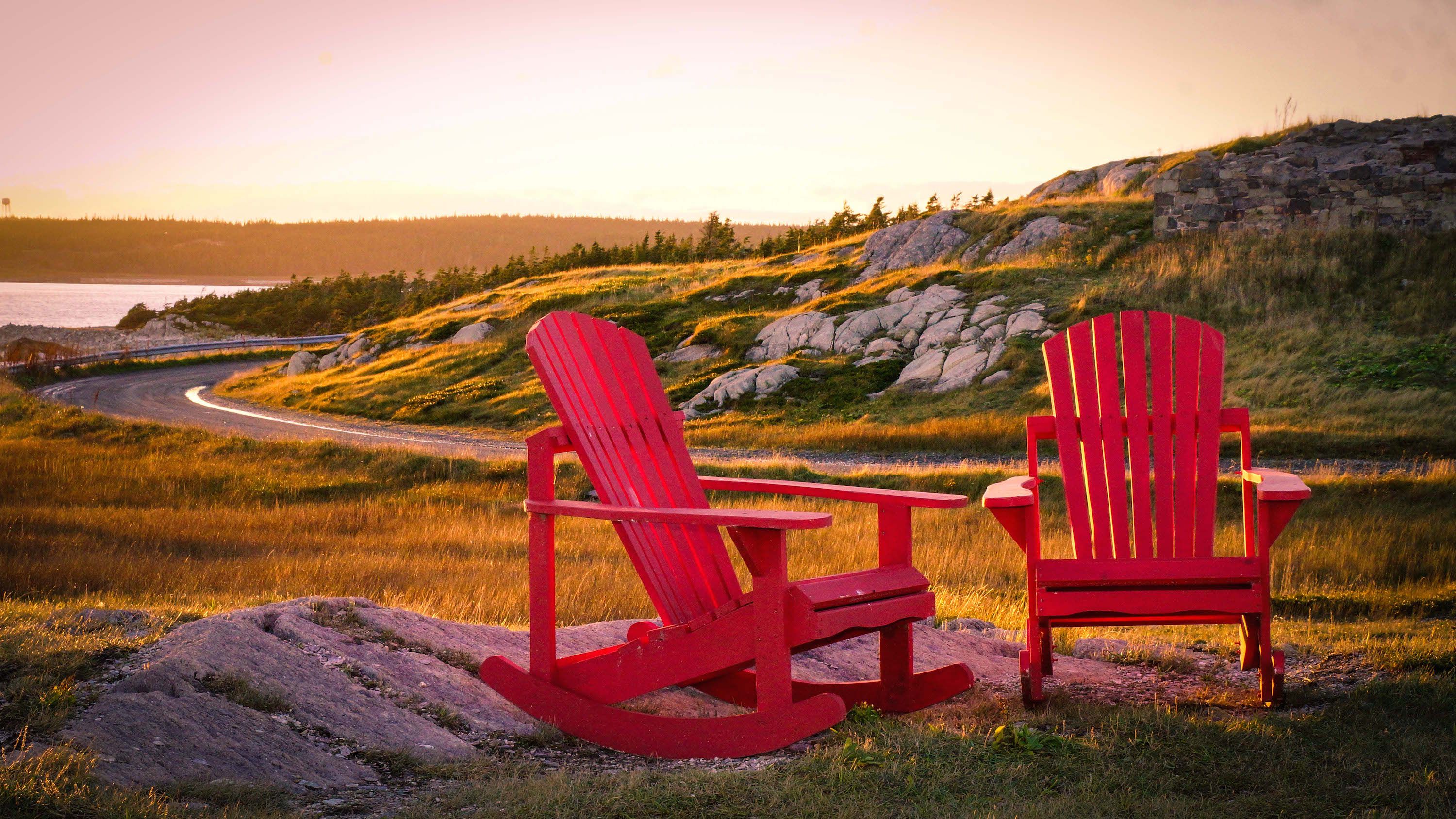 Two red lawn chairs on the coast in Louisbourg, Nova Scotia, Canada